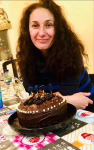 Photo of Yanna behind a chocolate cake
